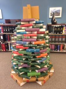 Tall colorful Christmas tree constructed of books.